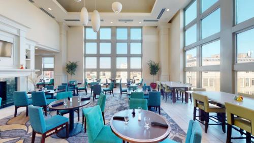 a restaurant with tables and chairs and windows at Hilton Garden Inn Philadelphia Center City in Philadelphia