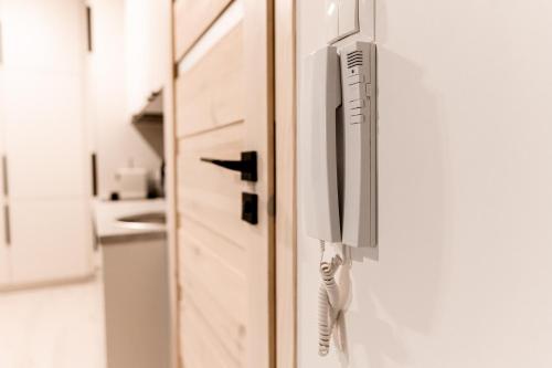 a white refrigerator with a phone on the door at Hop & Lulu Premium Apartments in Gollnow