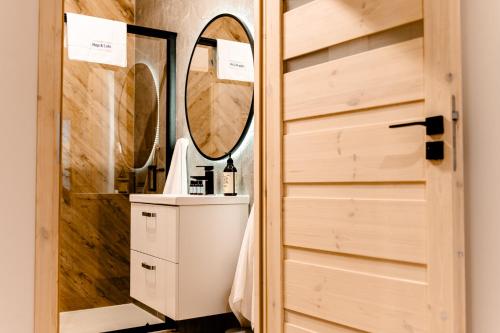 een badkamer met een wastafel en een spiegel bij Hop & Lulu Premium Apartments in Goleniów