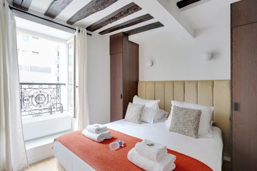 une chambre avec un lit avec des serviettes dessus dans l'établissement Amazing apartment 6P/2BR - Bastille, à Paris