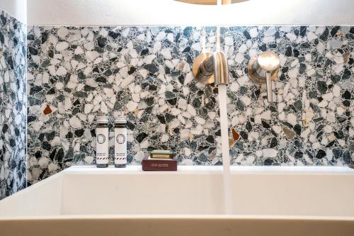 La salle de bains est pourvue d'un lavabo blanc et d'un mur à motifs floraux. dans l'établissement Amazing apartment 6P/2BR - Bastille, à Paris