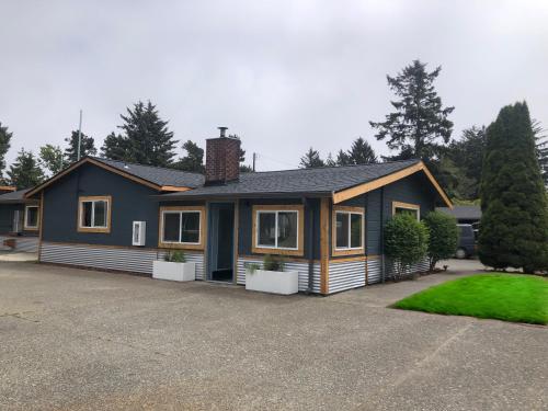 a house in a driveway with a yard at LOGE Westport in Westport