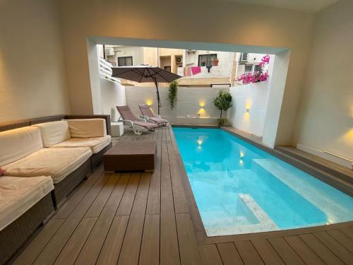 un salon avec une grande piscine dans l'établissement St Julians Apt with Pool, à San Ġiljan