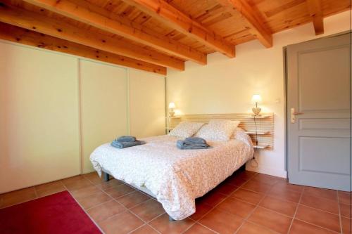 ein Schlafzimmer mit einem Bett in einem Zimmer mit Holzdecken in der Unterkunft Le jai alai in Saint-Jean-Pied-de-Port