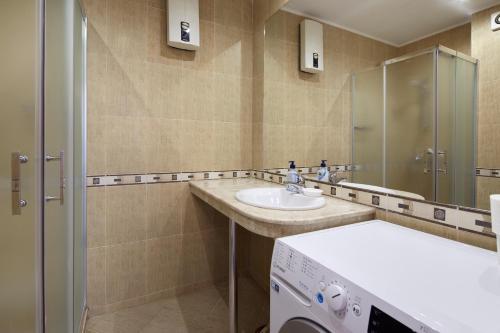 a bathroom with a sink and a washing machine at Infinity Apartment Nessebar in Nesebar