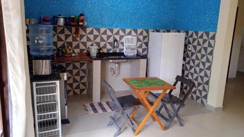 a small kitchen with a table and chairs in it at casaOCA in Lençóis