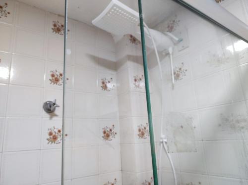 y baño con ducha y puerta de cristal. en Belo Apartamento no centro de Curitiba, en Curitiba