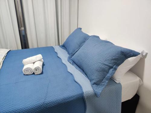 1 cama con 2 toallas y almohadas en Belo Apartamento no centro de Curitiba, en Curitiba