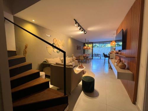 una sala de estar con una escalera que conduce a una sala de estar. en Kanui Casa Maré 107, en São Miguel dos Milagres