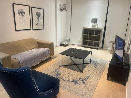 a living room with a couch and a coffee table at Stunning 2 Bedroom Apartment in London
