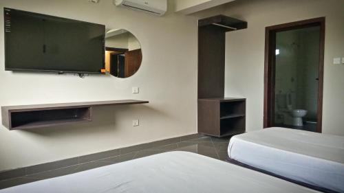 um quarto com 2 camas e uma televisão de ecrã plano em Ivory Park Hotel - Safari Waterworld em Nakuru