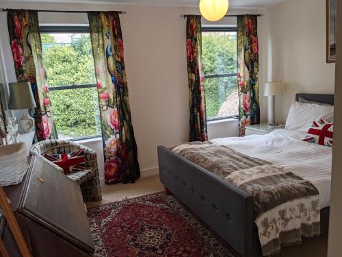 um quarto com uma cama e duas janelas em Panoramic sea views, sleeps 4, Torquay em Torquay