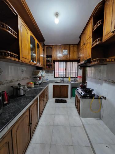 een grote keuken met houten kasten en een fornuis bij Dhanmondi Furnished Lake View Apartment in Dhaka