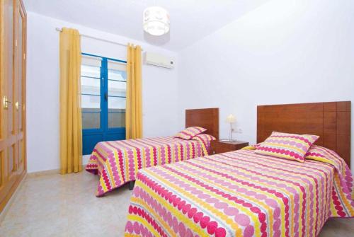 a bedroom with two beds and a window at Villa Acomari in Playa Blanca