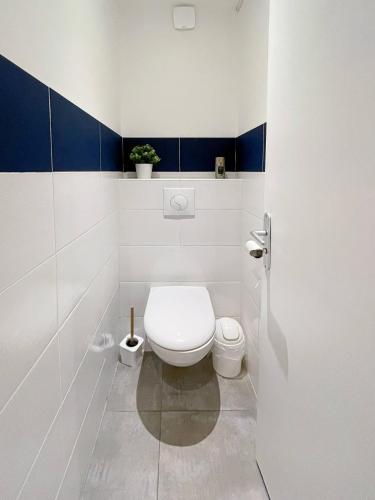 La salle de bains est pourvue de toilettes aux murs bleus et blancs. dans l'établissement Appart'hodromme Longchamp, à Rennes