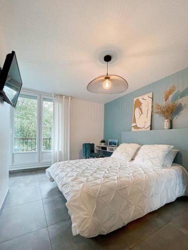 une chambre avec un lit blanc et une fenêtre dans l'établissement Appart'hodromme Longchamp, à Rennes