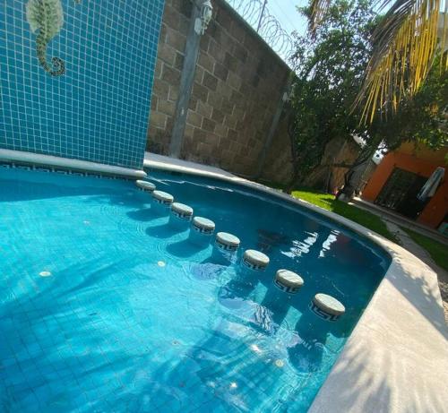 a swimming pool with a bunch of stools in it at Casa Emilia in Yautepec