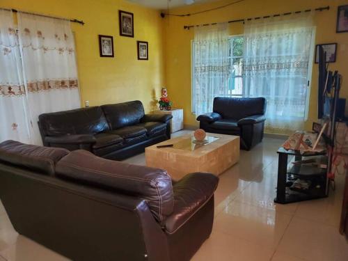 a living room with leather couches and a coffee table at Casa Emilia in Yautepec