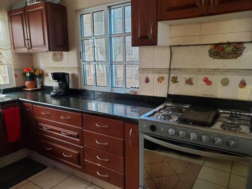 a kitchen with a stove and wooden cabinets at Casa Emilia in Yautepec