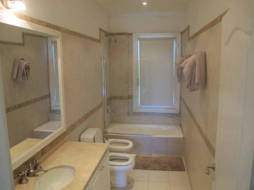 a bathroom with a sink and a toilet and a window at Cabaña romántica en la sierra in Yacanto