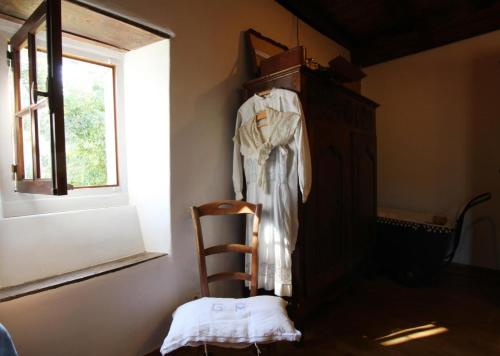 a chair in a room with a dress hanging on a wall at Behiagoitia in Larrau