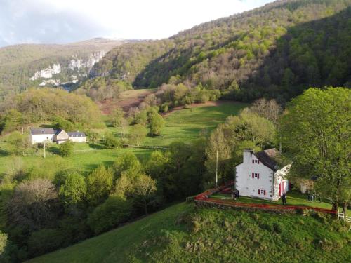 a white house on a hill in a valley at Behiagoitia in Larrau