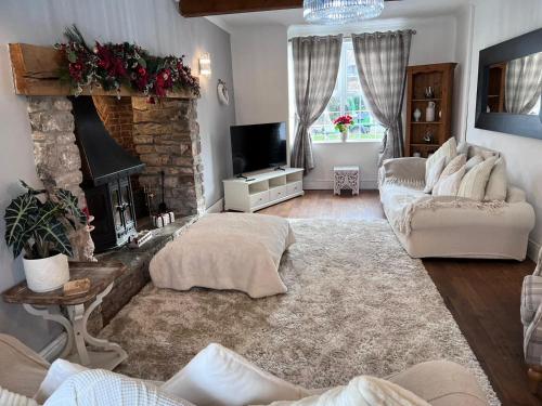 a living room with a couch and a fireplace at Family & friends get together birthday hot tub in Porthcawl