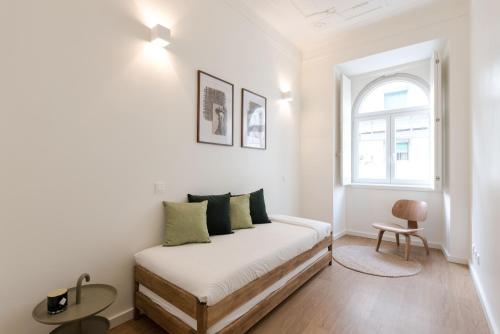 een witte slaapkamer met een bed en een raam bij Gorgeous Refurbished Apartments Graça in Lissabon