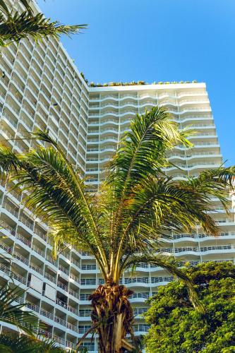 a tall building with a palm tree in front of it at View Talay Condominium by Vlad Property in Pattaya South