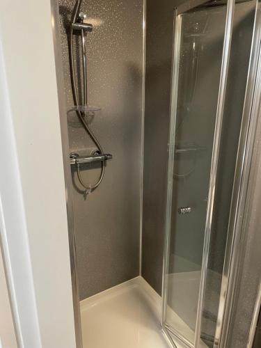 um chuveiro com uma porta de vidro na casa de banho em River side rooms em Southampton