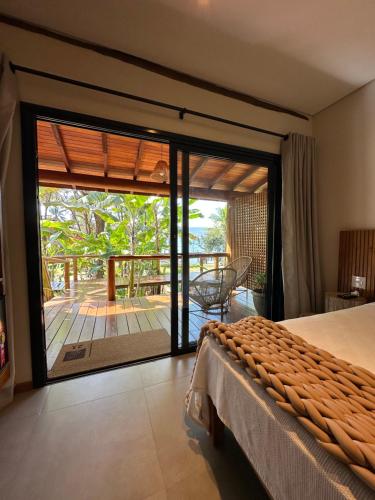 a bedroom with a bed and a view of a deck at Pousada da Pedra Rifaina in Rifaina