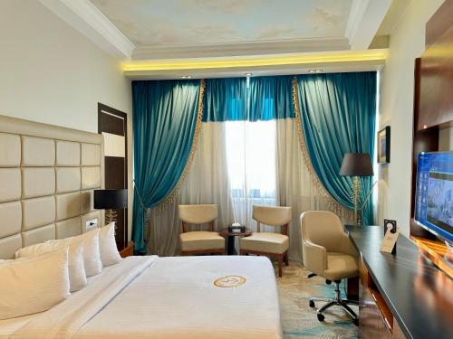 a hotel room with a bed and a desk and a television at Fleet Club Mahrousa in Alexandria