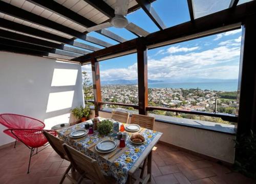 een eetkamer met een tafel, stoelen en ramen bij Casa Di Ulisse Vista Mare-Free Parking-Wi-Fi in San Felice Circeo