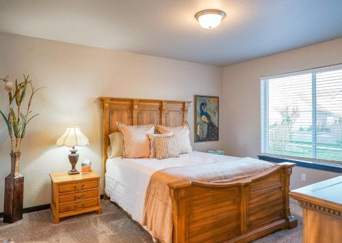 sypialnia z łóżkiem z drewnianym zagłówkiem i oknem w obiekcie Family home by CDA: many extras w mieście Post Falls