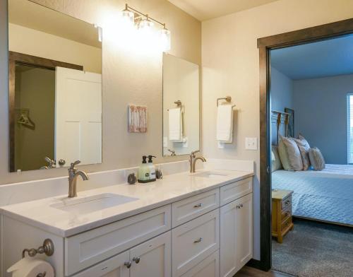 baño con lavabo, espejo y cama en Family home by CDA: many extras, en Post Falls