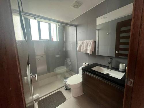 y baño con ducha, aseo y lavamanos. en Hotel poseidon piscina & jacuzzi en Manta