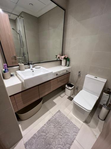 a bathroom with a sink and a toilet and a mirror at Modern Studio Center of Dubai in Dubai