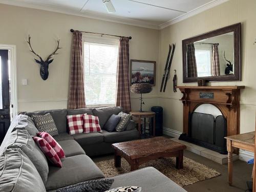 ein Wohnzimmer mit einem Sofa und einem Kamin in der Unterkunft Kosbys Cottage, Tongariro 