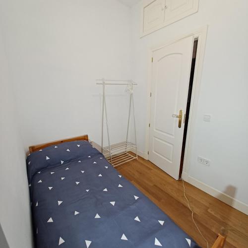 a bedroom with a bed with a blue comforter at VUT Casa de la Catedral Baja in Sigüenza