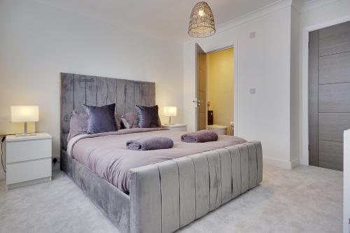 a bedroom with a large bed with purple pillows at 17 Banstead Road in Poole