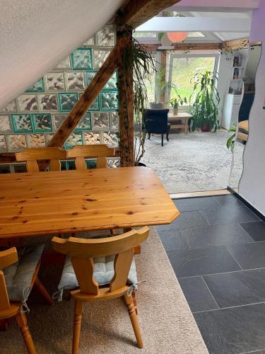 a wooden table and chairs in a room at Old Farmhouse Loft near Vaduz in Sevelen