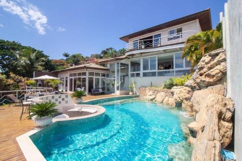 una piscina frente a una casa en Maravilhosa Mansão em Frente à Praia da Ferradura Por Luxury Rentals en Búzios