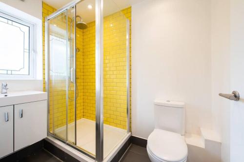 a bathroom with a shower and a toilet and a sink at Cozy 2-Bedroom Flat in Battersea in London