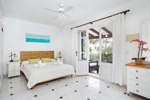 a bedroom with a bed and a sliding glass door at Villa Binilisa in Binibeca