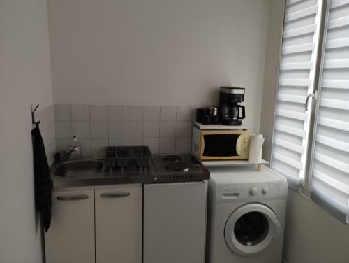 een keuken met een wasmachine en een magnetron bij studio charmant canapé lit Netflix Prime video in Le Havre