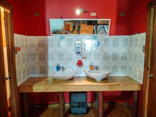 baño con 2 lavabos en una encimera de madera en Hostal & Cabañas Luna del Sur en Cucao