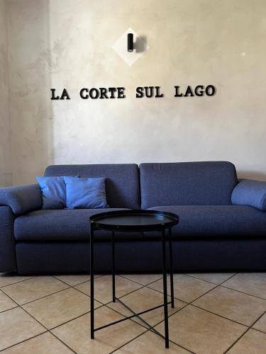 ein blaues Sofa mit einem Tisch im Wohnzimmer in der Unterkunft La Corte Sul Lago casa vacanze in Pisogne