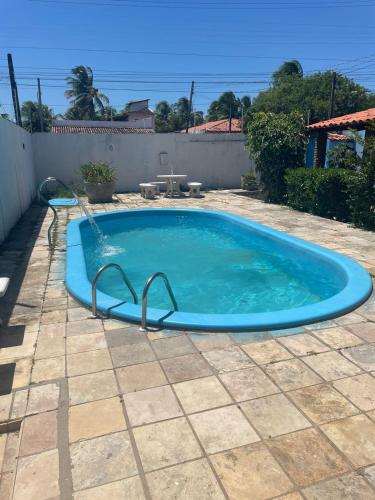 a large blue swimming pool in a yard at Casa Oceano in Marechal Deodoro