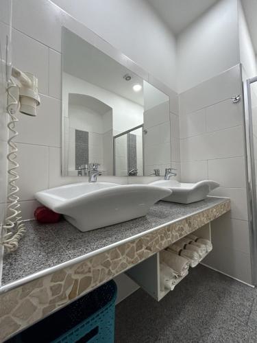 a white bathroom with a large sink and a mirror at Cozy City Center Apartments in Vienna