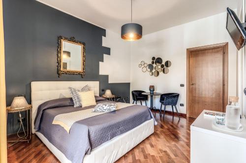 een slaapkamer met een bed en een tafel met stoelen bij Stasera a casa da M.E. in Rome
